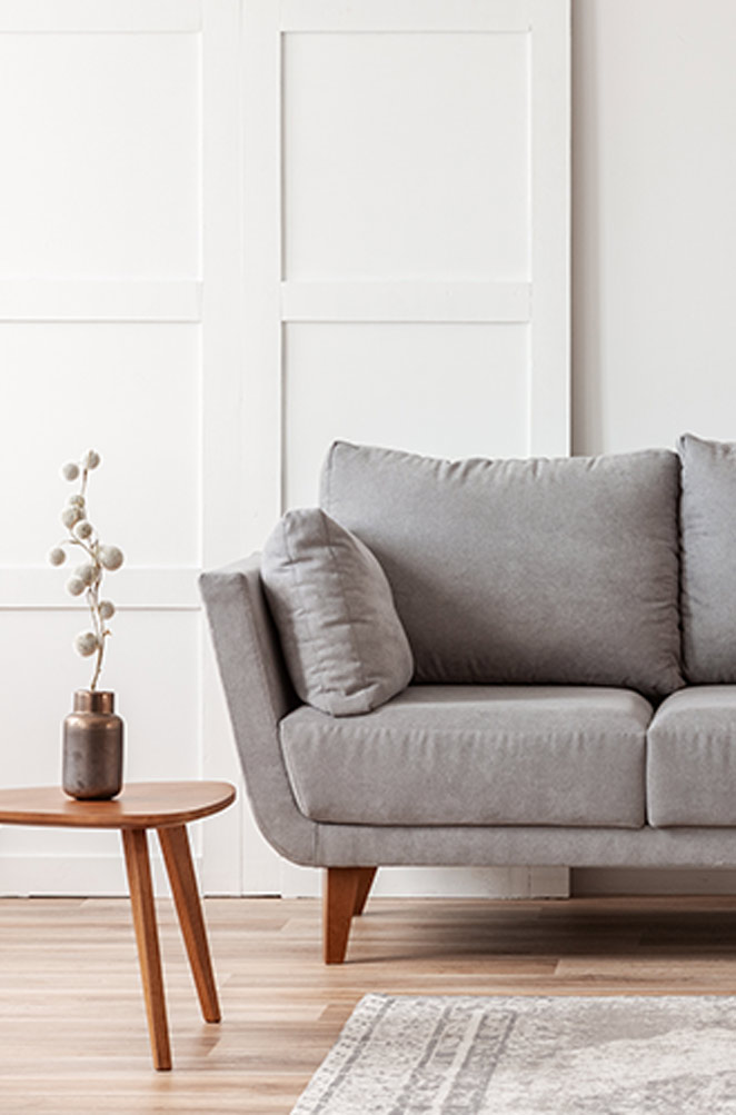 A gray couch sitting in the middle of a room.