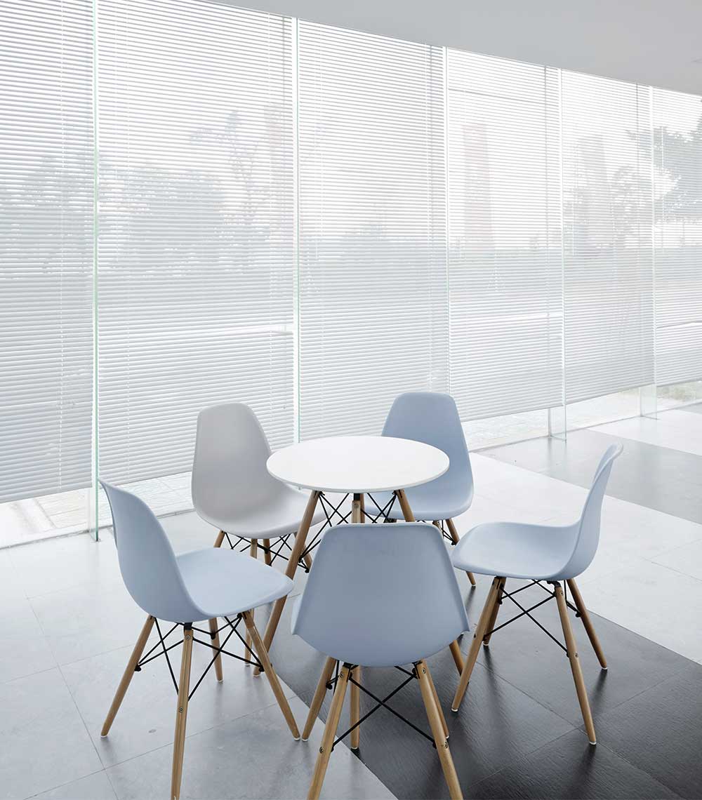 A table and chairs in front of a window.