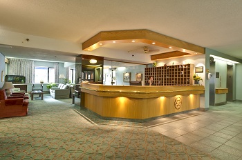 A large lobby with a bar and many chairs.